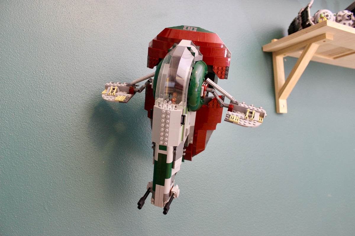 LEGO Slave I 8097 on the wall mount next to a wooden shelf