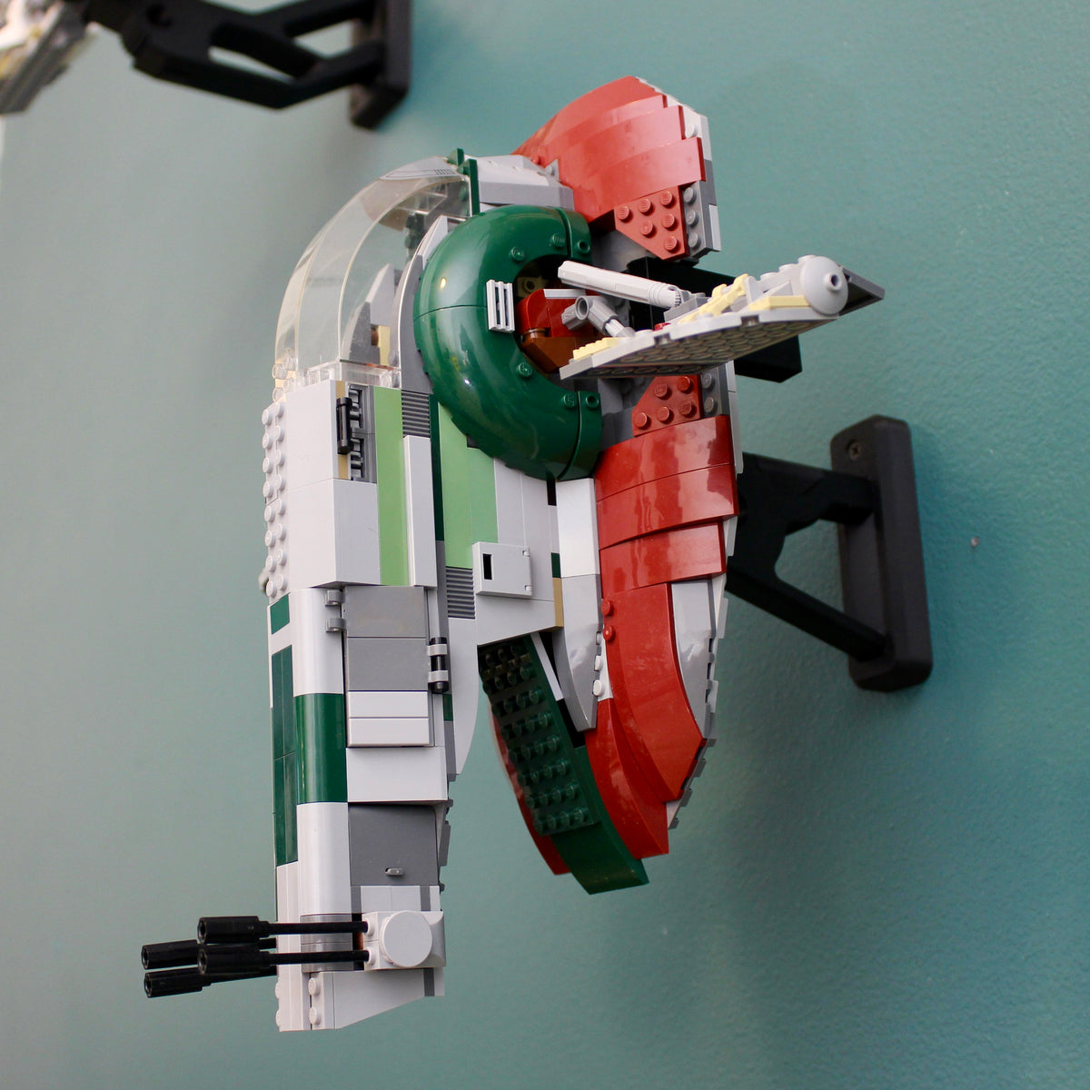 LEGO Star Wars Slave I 8097 mounted upright on a teal wall, side view showing the black wall mount