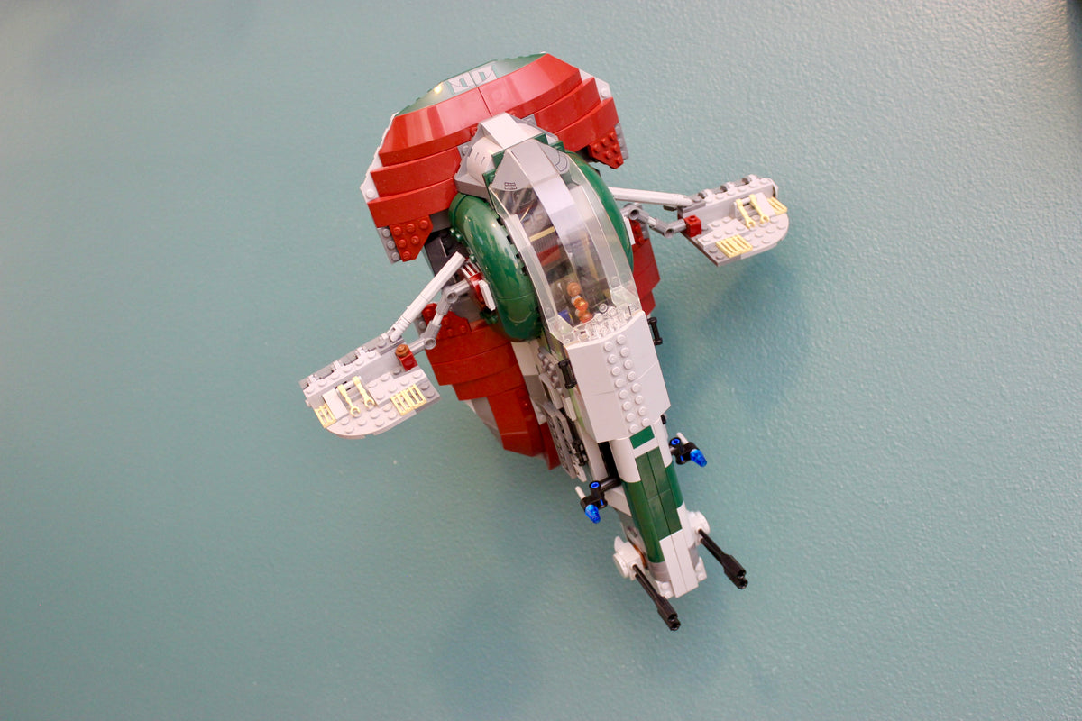 LEGO Star Wars Slave I 8097 on its wall mount against a teal wall, front view