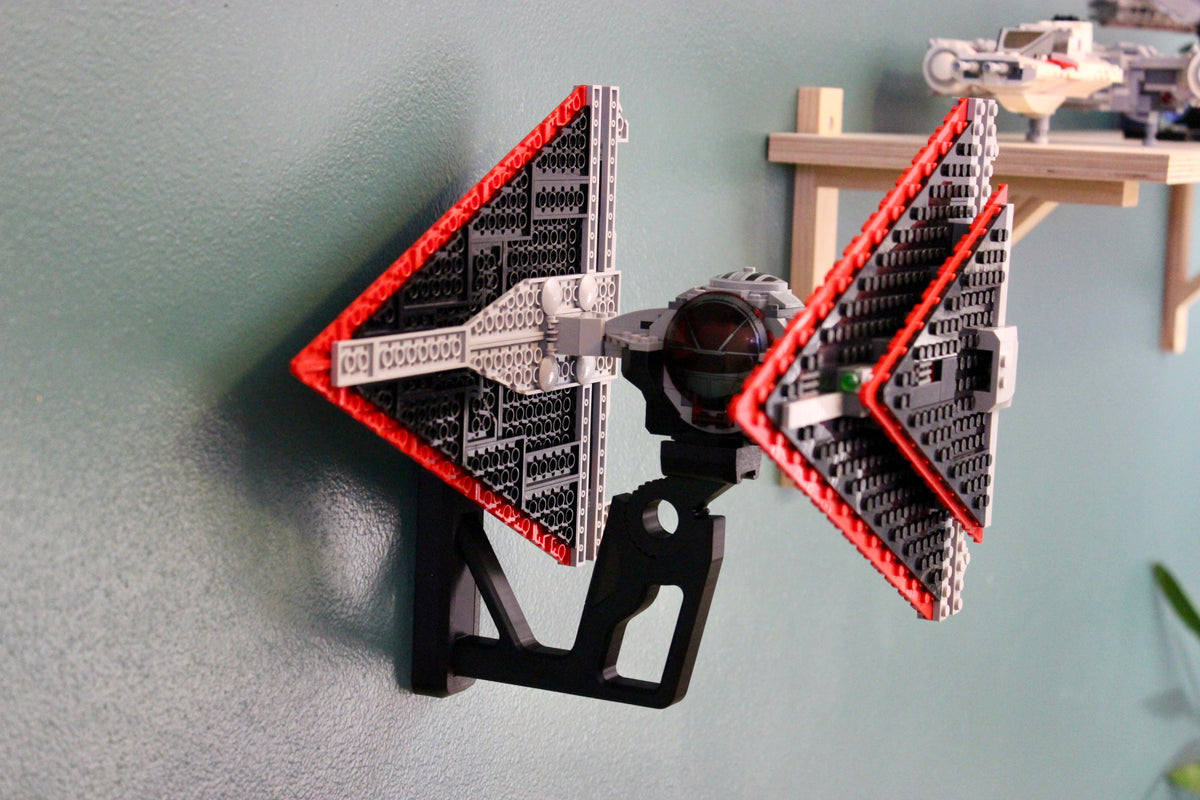 LEGO Sith TIE Fighter 75272 angled on its wall mount beside a wooden shelf