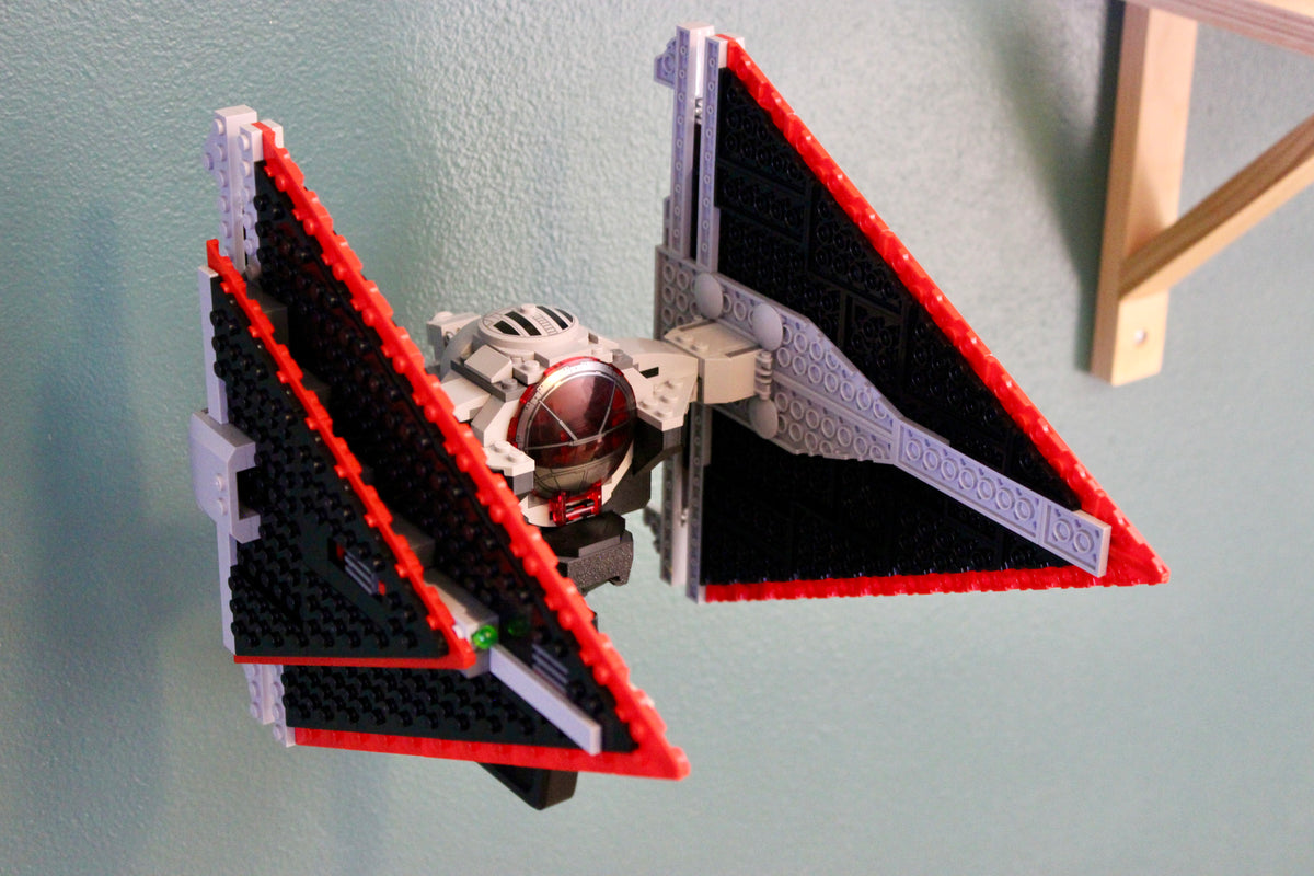 LEGO Sith TIE Fighter 75272 tilted on the wall mount to show its red-edged wings