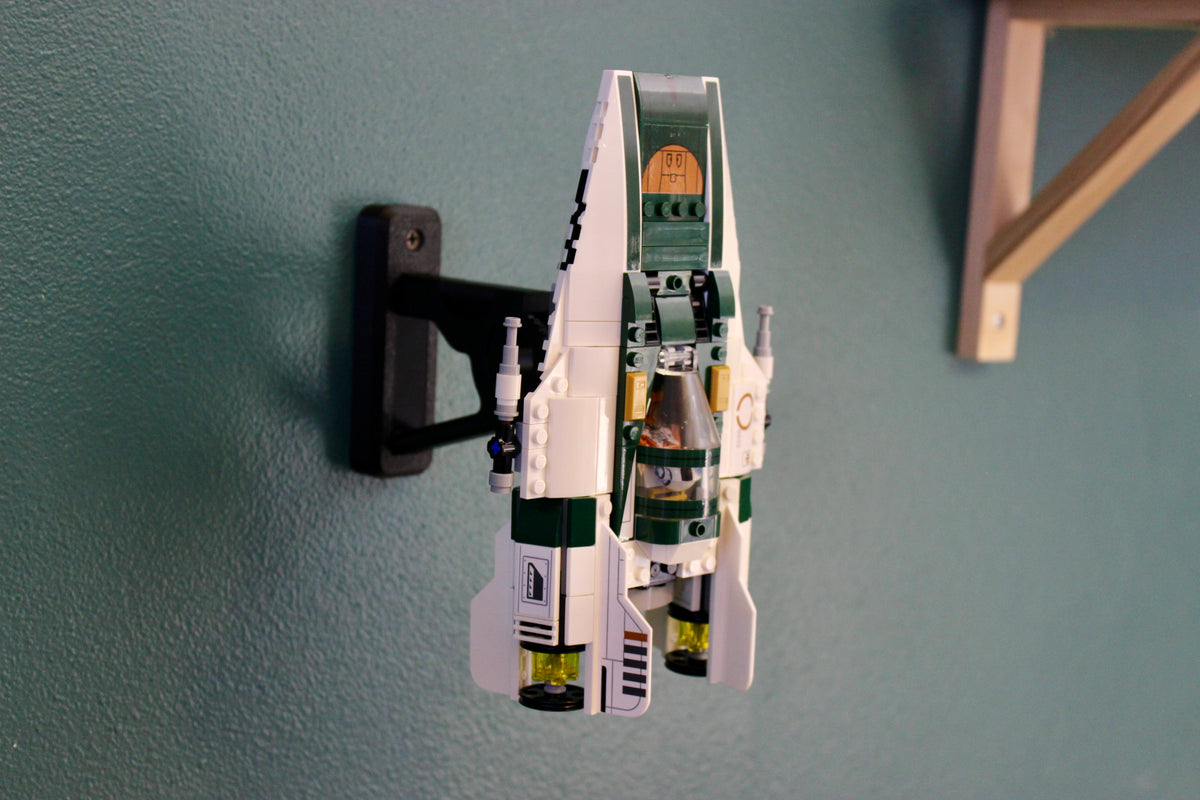 LEGO Resistance A-Wing Starfighter 75248 mounted nose-up on the wall beside a wooden shelf bracket