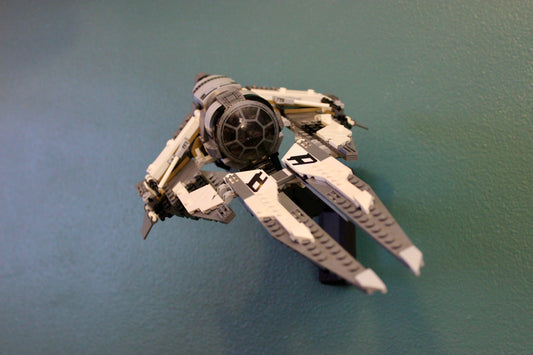 LEGO Star Wars Black Ace TIE Interceptor 75242 on its black wall mount against a teal wall, angled from above