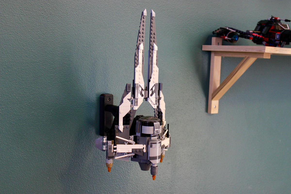 LEGO Black Ace TIE Interceptor 75242 mounted nose-up on the wall beside a wooden shelf